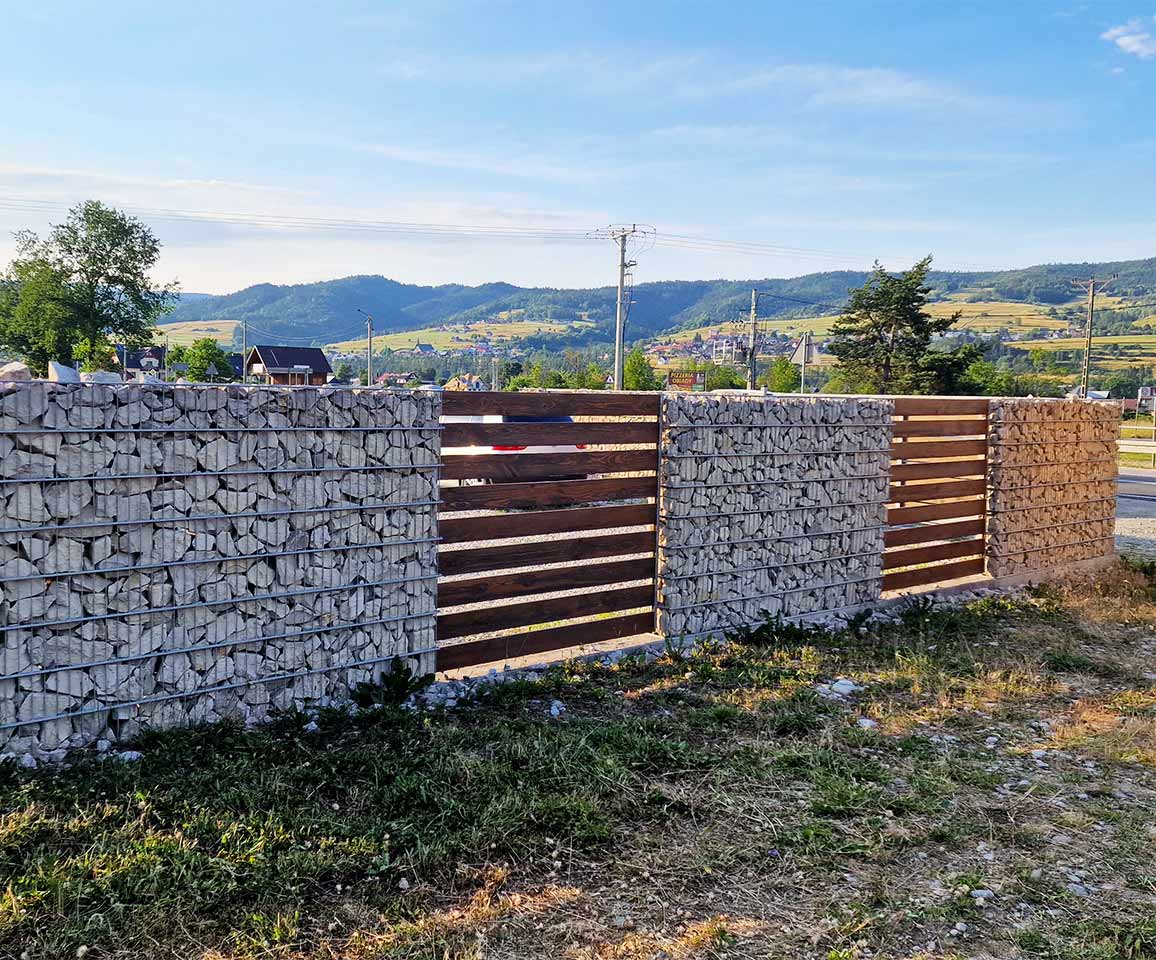 oplotenie domu z gabionov s drevenou výplňou